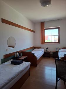 a hotel room with two beds and a mirror at Penzion Borlitz in Pohořelice