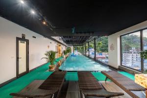 a large swimming pool in a building with chairs at Catba Vista Hotel - New 2026 - Infinity Pool in Cat Ba
