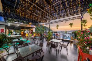 a restaurant with tables and chairs and a balcony at Catba Vista Hotel - New 2026 - Infinity Pool in Cat Ba