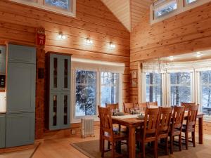 a dining room with a wooden table and chairs at Mäntypirtti Log Villa in Rovaniemi