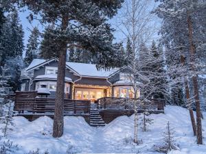 a house in the winter with snow on the ground at Mäntypirtti Log Villa in Rovaniemi