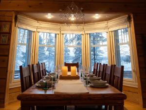 a dining room with a long table with chairs at Mäntypirtti Log Villa in Rovaniemi +26 photos