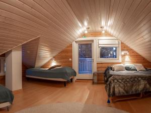 a large room with two beds in a house at Mäntypirtti Log Villa in Rovaniemi