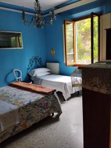 ein blaues Zimmer mit zwei Betten und einem Fenster in der Unterkunft 3B Firenze in Capraia e Limite