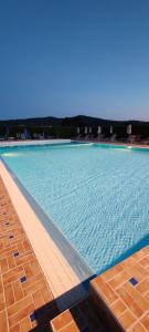 a large swimming pool with blue water at Villa Cilento Parking e Sosta Camper in Capaccio-Paestum