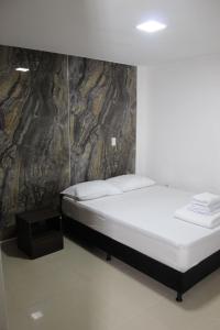 a bedroom with a bed and a stone wall at Lumière House in Medellín