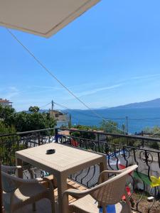 a table and chairs on a balcony with a view of the ocean at Dub Hostel Saranda in Sarandë