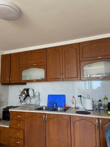 a kitchen with wooden cabinets and a sink at Dub Hostel Saranda in Sarandë