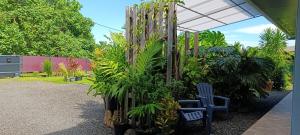 a garden with a blue chair and some plants at Teonetere Iti in Teahupoo