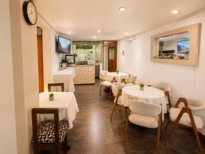 a restaurant with white tables and chairs and a counter at Mandala Rooms & Services in Arequipa