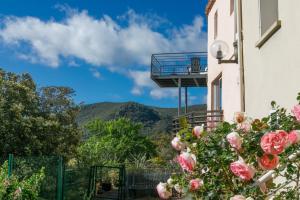 a building with a balcony and flowers in the foreground at Pyrénées Mon Amour in Felluns