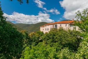 a house in the middle of trees with mountains in the background at Pyrénées Mon Amour in Felluns