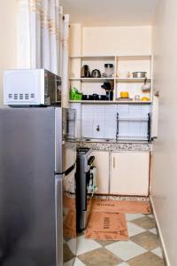 a kitchen with a refrigerator and a tiled floor at Meyer Stays in Kilifi