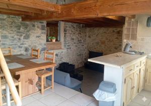 a kitchen with a table and a table and chairs at Maisonnette en pierre in Saint-Victor-de-Malcap