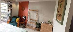 a bedroom with a bed and a mirror and a chair at Teonetere Iti in Teahupoo