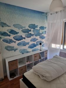 a bedroom with a mural of clouds on the wall at Appartement 30 m de la mer in La Turballe
