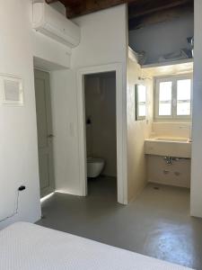 a white bathroom with a sink and a toilet at Marpissa - Traditional House in Márpissa