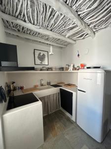 a kitchen with a white refrigerator and a counter at Marpissa - Traditional House in Márpissa