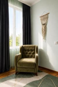 a living room with a chair and a window at Green bunny ArtHouse in Martvili