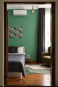 a bedroom with green walls and a bed and a chair at Green bunny ArtHouse in Martvili