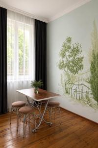 a dining room with a table and stools at Green bunny ArtHouse in Martvili