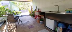 a kitchen with a sink and a table and a counter at Teonetere Iti in Teahupoo