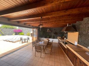 an outdoor kitchen with a table and chairs on a patio at Villa Feel in Tías