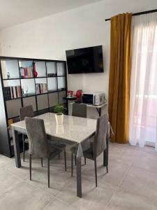 a dining table and chairs in a living room at Apartment, Sulina's House in Campofelice di Roccella