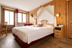 a bedroom with a large bed with a canopy at Camana Veglia in Livigno