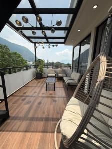 ein Balkon mit Sofa und Stühlen auf dem Dach in der Unterkunft Hotel HS Confort in Orizaba