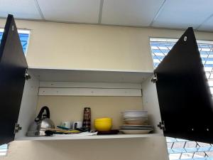 a kitchen with a shelf with plates and utensils at Nómada San Miguel in Colonia Milagro de La Paz