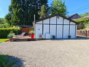a large white garage with a roof at Le Rensy in Ferrières