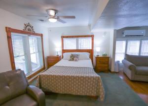 a bedroom with a bed and a couch and windows at Over the Rainbow Suites in Eureka Springs
