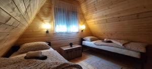a room with two beds in a wooden cabin at Apartment & Cottage - Tune in Ripci