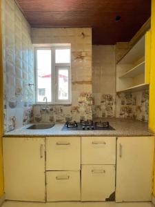 an old kitchen with a sink and a window at Mahadevs Mansion in Rishīkesh