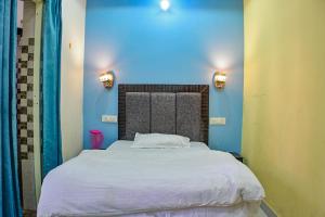 a bedroom with a large bed with blue walls at Mahadevs Mansion in Rishīkesh