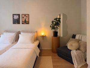 a bedroom with two beds and a couch and a plant at Central location with sauna, private yard & parking in Rovaniemi