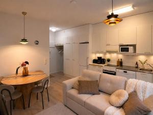 a living room with a couch and a table and a kitchen at Central location with sauna, private yard & parking in Rovaniemi