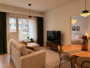a living room with a couch and a television and a bed at Central location with sauna, private yard & parking in Rovaniemi