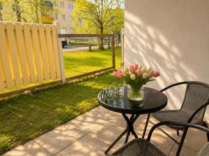 a table with a vase of flowers on a patio at Central location with sauna, private yard & parking in Rovaniemi