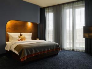 a bedroom with a large bed and a large window at 25hours Hotel Hamburg HafenCity in Hamburg