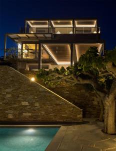 a house with a swimming pool at night at Astraea Villa in Karistos