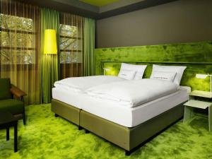 a bedroom with a large bed and a green wall at 25hours Hotel The Goldman in Frankfurt +35 photos