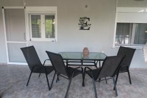 a glass table and chairs in a room at Efterpi seaside house in Chrysi Ammoudia