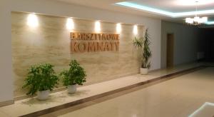 a lobby with three potted plants on a wall at Apartament Darłówko in Darlowko +12 photos