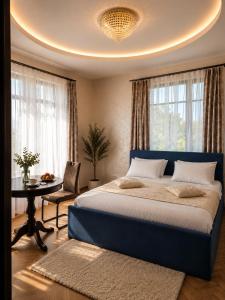 a bedroom with a blue bed and a table at GRAND APARTMENT BALTEZERS in Riga