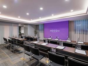 a conference room with tables and chairs and a purple screen at Mercure Hefei Huaihe Road in Hefei