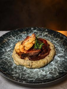 a plate of food with meat and shrimp on it at Béni golf club Clervaux hôtel & Restaurant in Eselborn