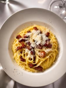 a white bowl of pasta with cheese and bacon at Béni golf club Clervaux hôtel & Restaurant in Eselborn +4 photos
