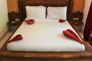 a bed with two red slippers on top of it at Sagando Bungalow in Michamvi